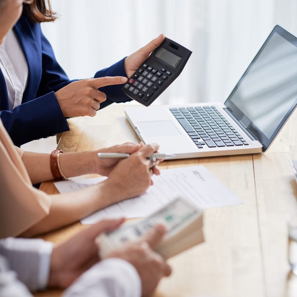 Real estate agent helping senior couple to calculate mortgage payment and down payment